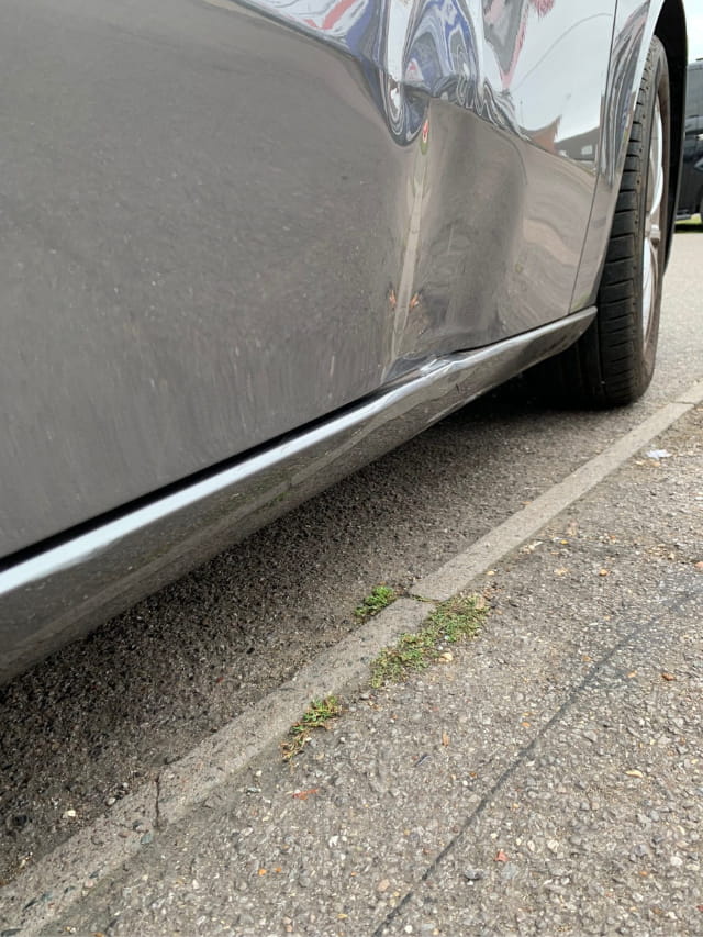 The dented door of the Mercedes