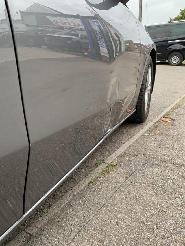 The dented door of the Mercedes