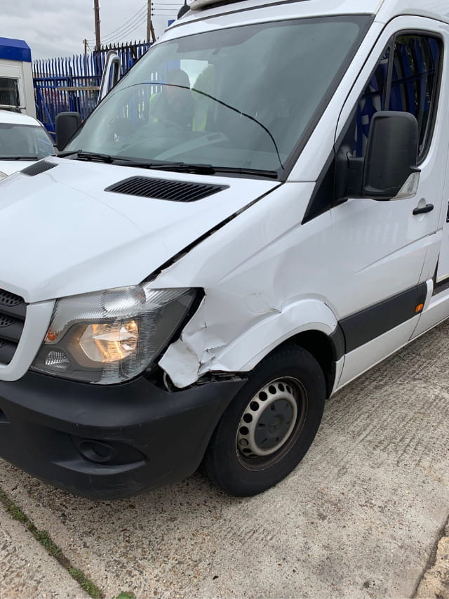 The dented wing of the Mercedes van